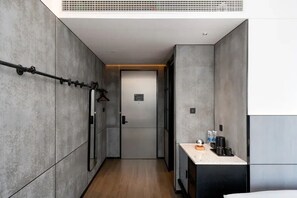 A narrow hallway with a door at the end, a towel rack on the left, and a small kitchenette area on the right. - SSAW Yintai Boutique Hotel Qiandao Lake (Hangzhou)