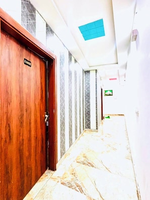 A hallway with a wooden door marked '103' and a tiled floor. - PP GUEST HOUSE (Agra)