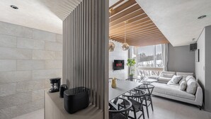 A modern living space with a kitchen area, a dining table with chairs, a sofa, and a TV mounted on the wall. - FURANO ECLAT (Furano)