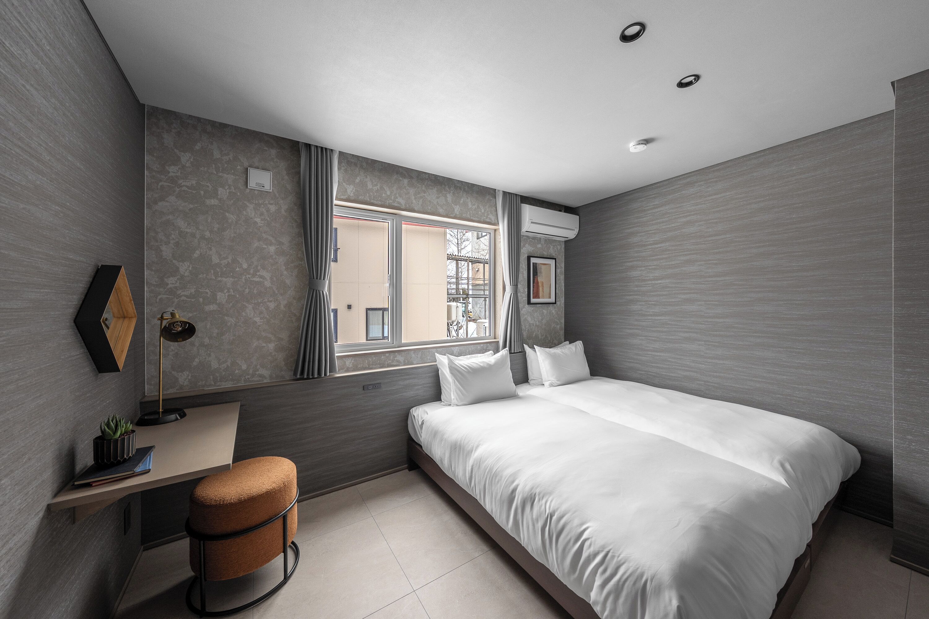 Une chambre moderne avec un grand lit, un bureau et une fenêtre.
