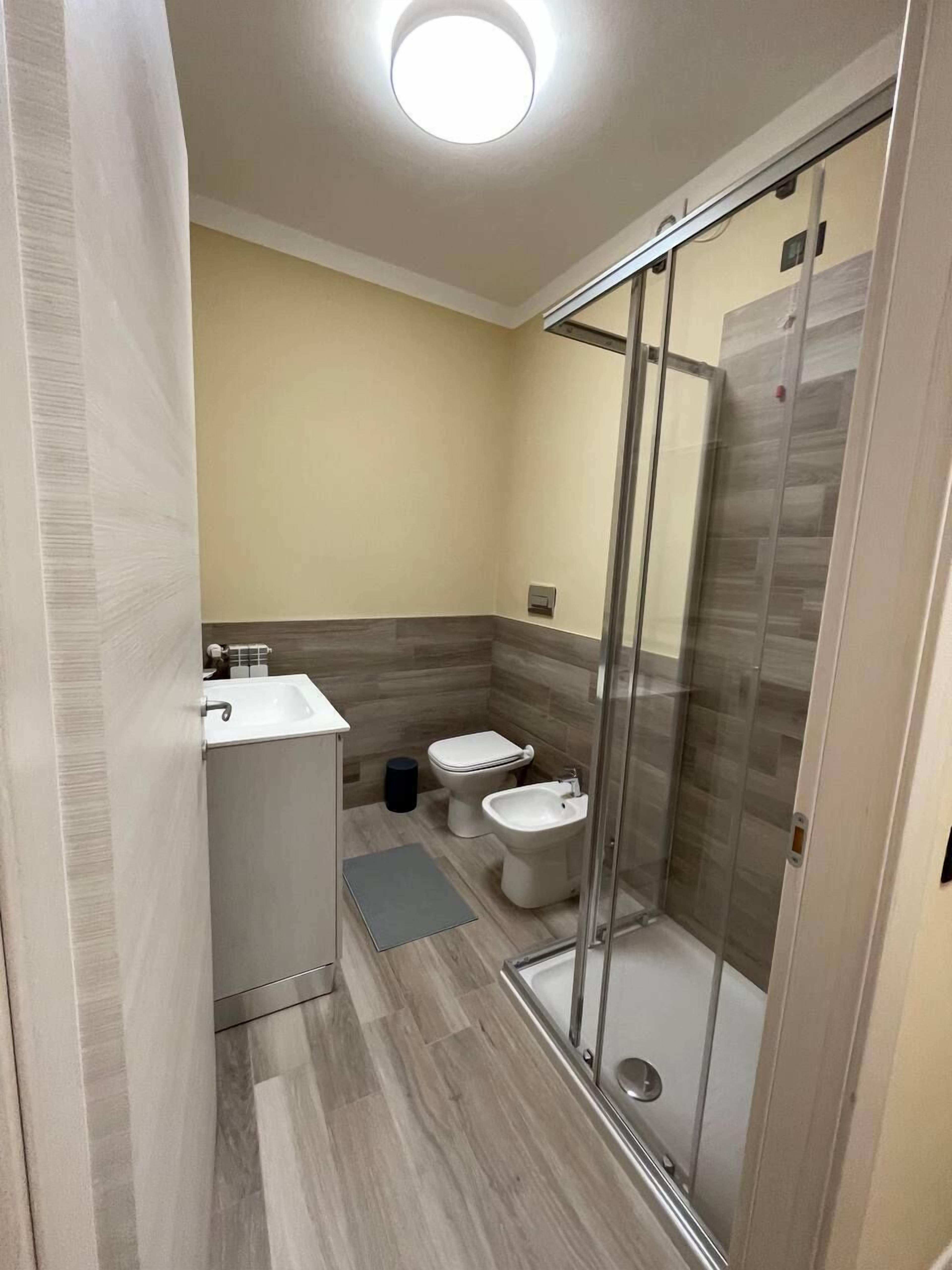 Un baño moderno con ducha, inodoro, bidé y lavabo.