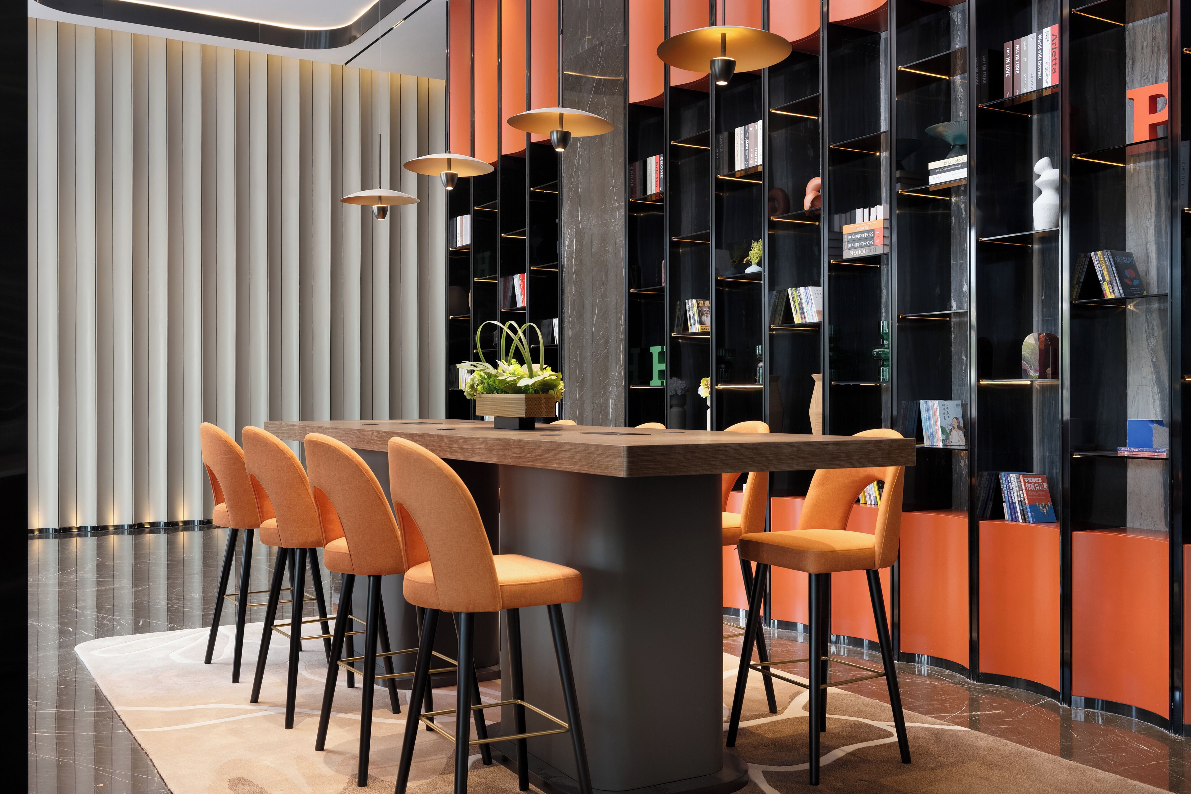 A modern bar area with a central island, bar stools, and a bookshelf filled with books and decorative items.
