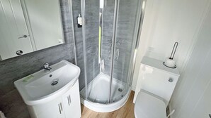 Een badkamer met een douchecabine, een wastafel en een toilet.