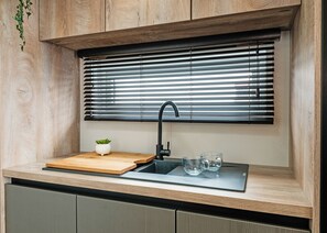 A kitchen with a wooden countertop, a sink, a potted plant, and a window with blinds. - 1 bedroom accommodation in Boston (Boston)
