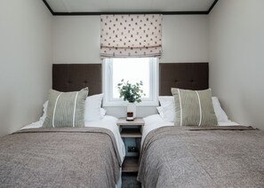 A twin room with two beds, a window with a plant, and a bedside table with a lamp. - 1 bedroom accommodation in Boston (Boston)
