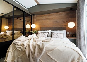 A modern bedroom with a large bed, a wooden headboard, and a skylight. - 1 bedroom accommodation in Boston (Boston)