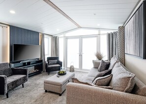 A modern living room with a flat-screen TV, comfortable seating, and a large window. - 1 bedroom accommodation in Boston (Boston)