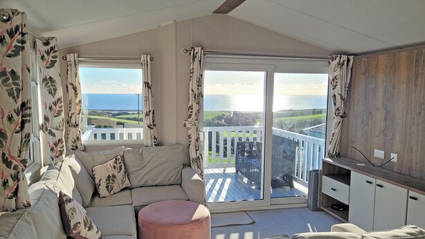 Een balkon met een bank, een poef en een houten kast.
