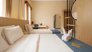 A hotel room with two beds, a desk, a chair, a wardrobe, and a window with curtains. - Tripletree Ciptaningati Culture Hotel (Batu)