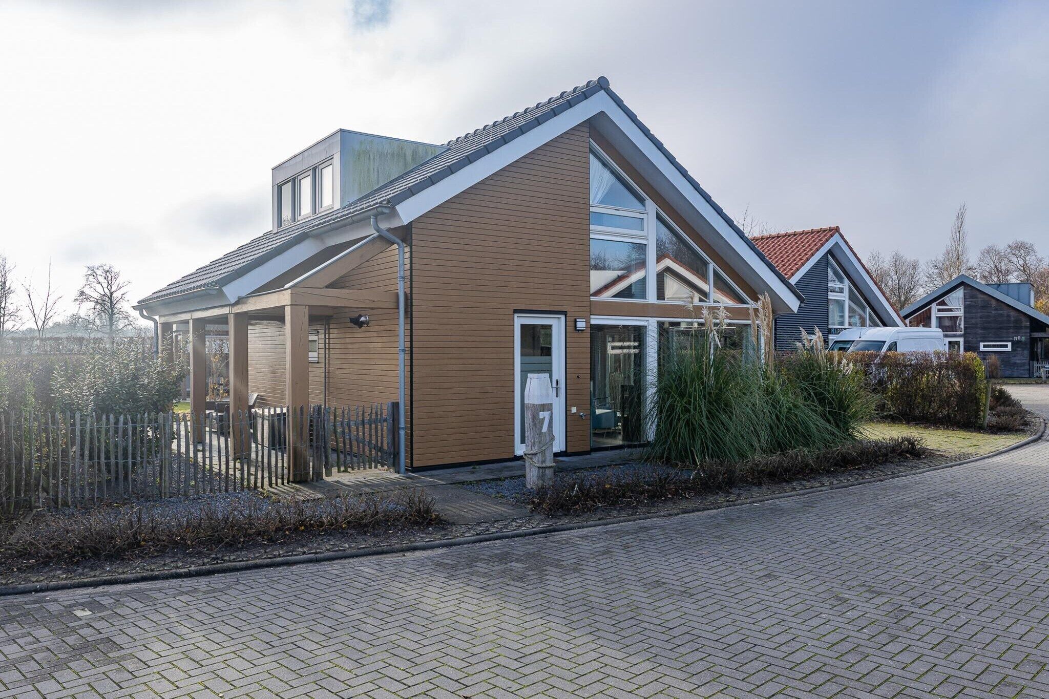 A modern house with a covered porch, a visible garage, and a paved driveway.