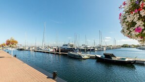 A marina with several boats docked, a wooden walkway, and a clear sky. - Zeeland Luxury Villa near Beach (Renesse)