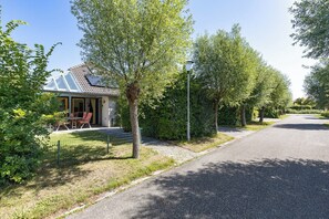Ein Wohnhaus mit Haus, überdachter Terrasse und gepflasterter Auffahrt.