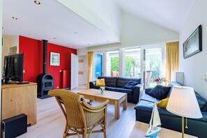 Ein modernes Wohnzimmer mit Kamin, einer Couch, einem Couchtisch und einem Fernseher.
