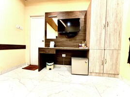 Un baño con lavamanos, espejo y televisor montado en la pared.