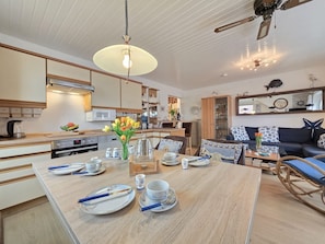 Una cucina moderna con zona pranzo, mobili in legno e una ventola a soffitto.
