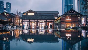 A waterfront building with a traditional architectural style, featuring storefronts for Breguet and Omega watches.