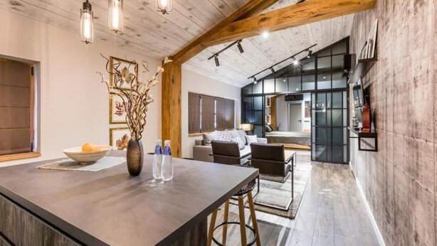 A spacious kitchen with a large island, wooden beams, and pendant lighting. - Boutique Hotel Casa Verdi (Veliko Tarnovo)