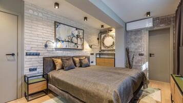 Un dormitorio moderno con una cama grande, una pared de ladrillo y obras de arte.