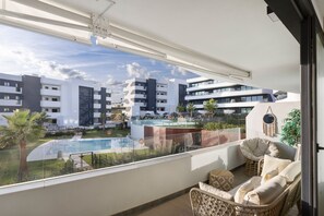 A balcony with a view of a swimming pool and modern buildings. - Premium Apartment With Terrace in Higuer n (Fuengirola)
