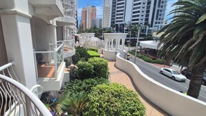A residential building with balconies, a garden area, and a street view. - PHOENICIAN RESORT- Renovated 2 Bed + 2 Bath Unit in the Heart of Broadbeach (Broadbeach)