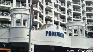 A multi-story hotel with balconies, a prominent 'PHOENIX' sign, and a circular structure on the ground floor. - PHOENICIAN RESORT- Renovated 2 Bed + 2 Bath Unit in the Heart of Broadbeach (Broadbeach)