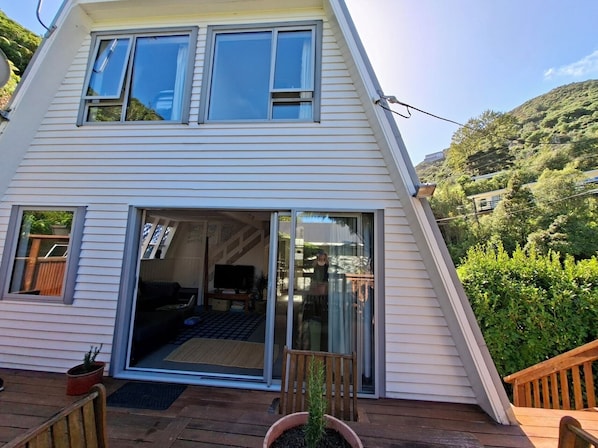 A two-story house with a large sliding glass door leading to a balcony.