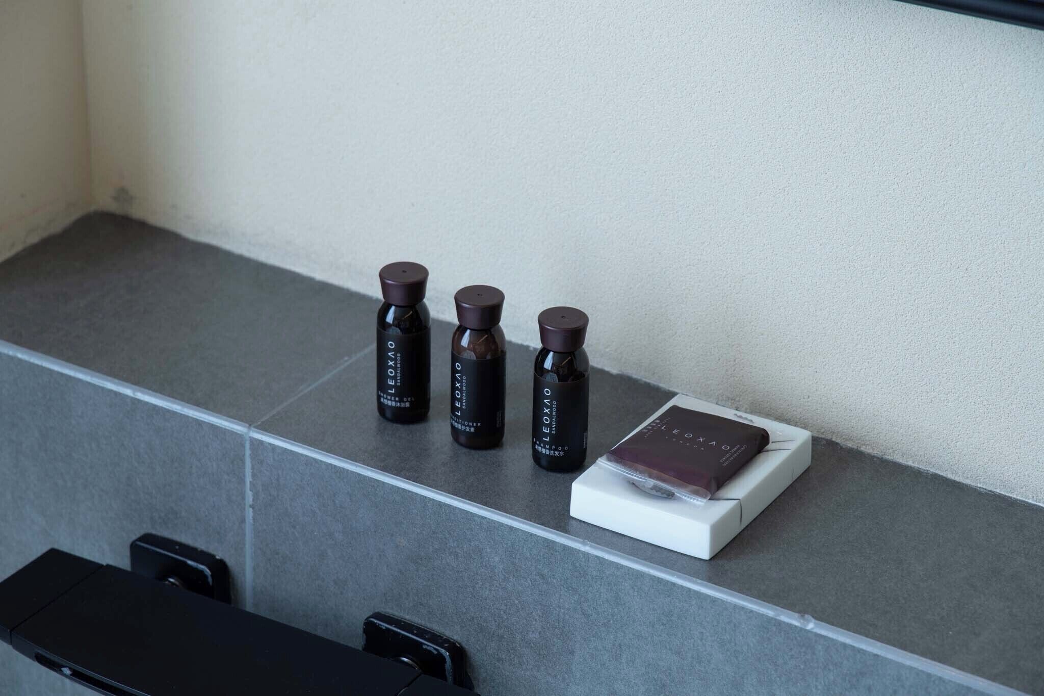 A countertop with three small bottles and a book on a white box.