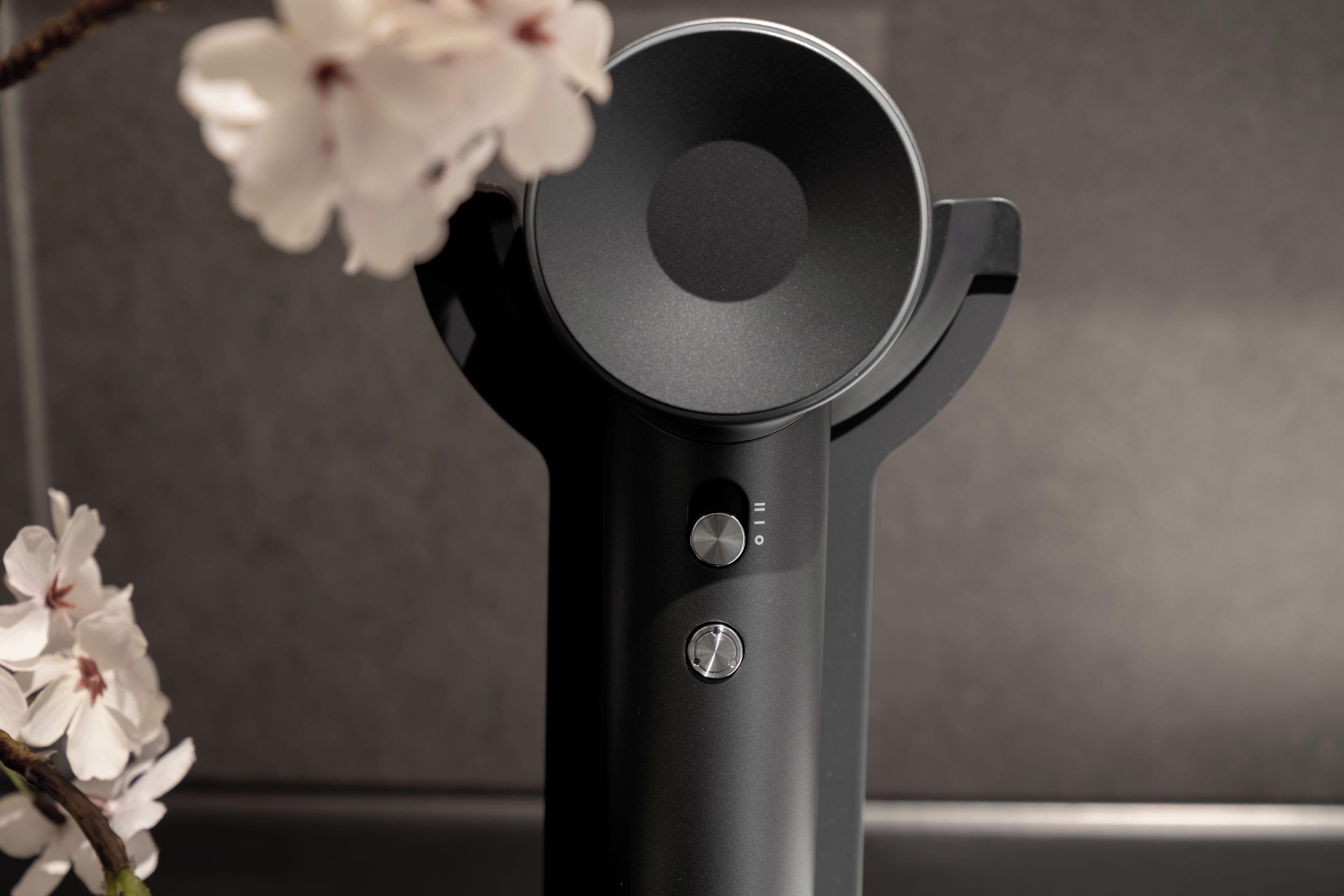A black, modern, cylindrical object with two knobs and a circular top, possibly a piece of equipment or furniture.