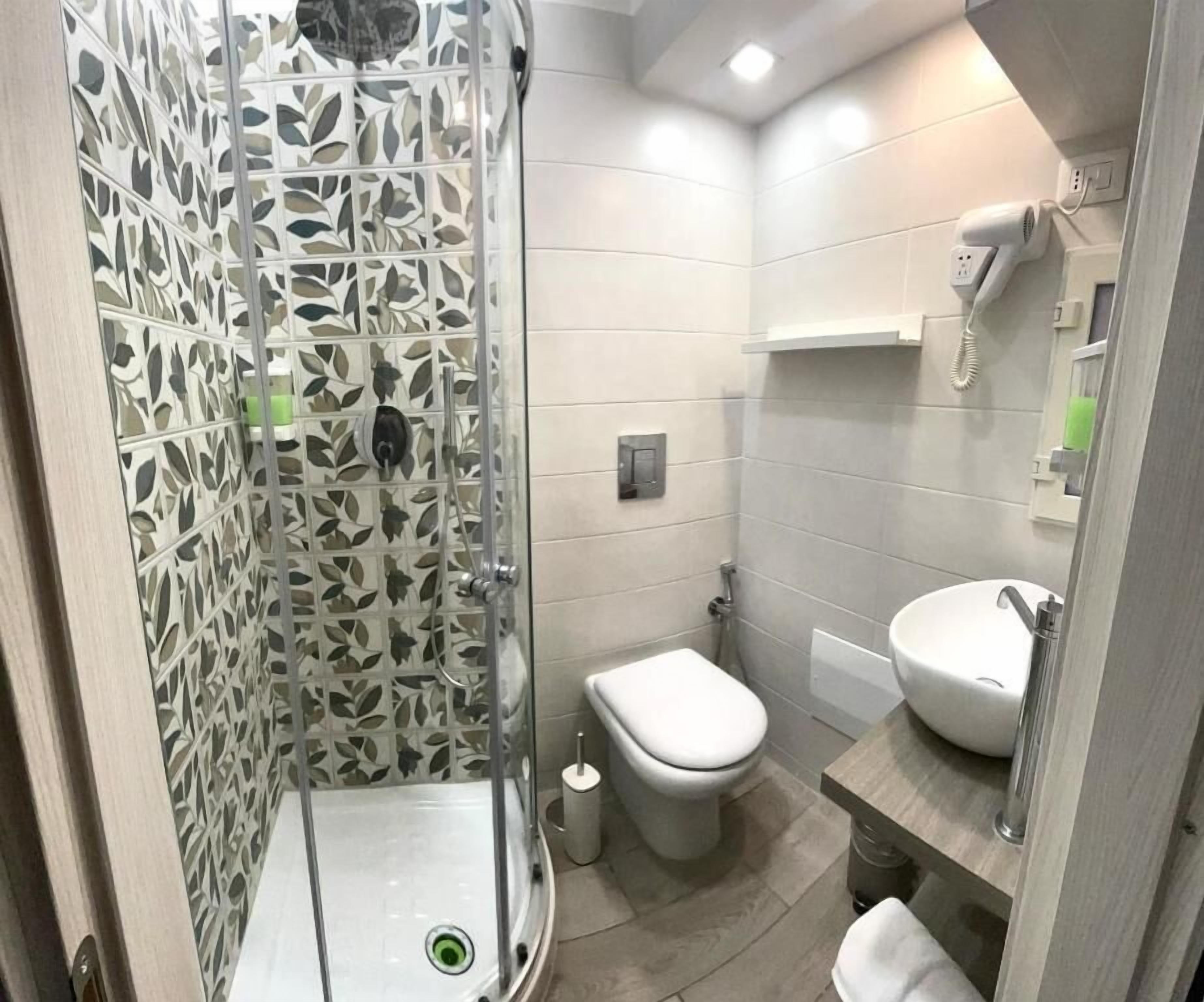 Un baño con cabina de ducha, inodoro y lavabo.