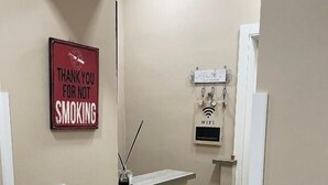 Ένας διάδρομος με έναν πάγκο υποδοχής, μια πινακίδα που αναγράφει «Σας ευχαριστούμε που δεν καπνίζετε» και μια πινακίδα που υποδεικνύει τη διαθεσιμότητα Wi-Fi.