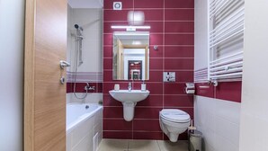 A compact bathroom with a bathtub, sink, and toilet.