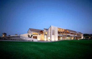 A modern building with a stone facade, large windows, and a flat roof. - Fantastic 4BR Residence with Ocean View (Tsada)