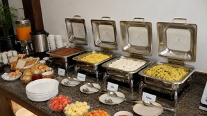 Een buffet met diverse gerechten en bestek.