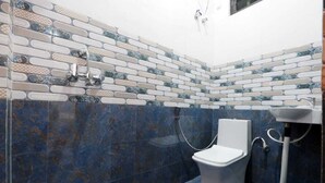 Une salle de bain avec des toilettes, une douche et un lavabo.