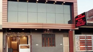 Une façade d’hôtel moderne, dotée d’une grande entrée en verre, d’un comptoir d’accueil et d’une enseigne indiquant le nom et l’emplacement de l’hôtel.