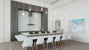A modern kitchen with a central island, white chairs, pendant lighting, and a large painting on the wall. - King Bed | Mins to Stampede | Cgy Twr View | UG Pk (Calgary)