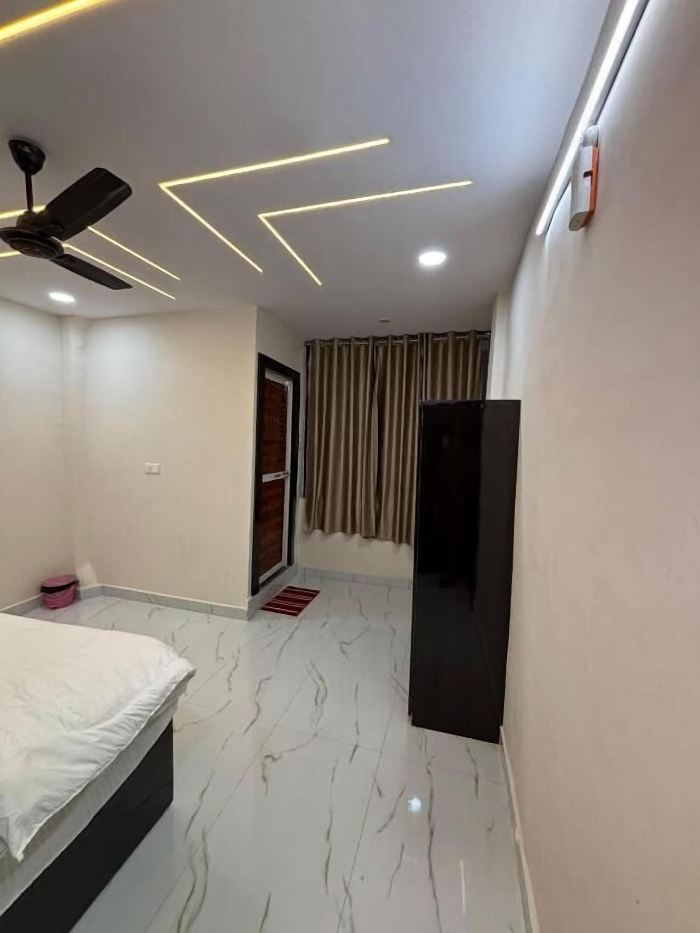 A bedroom with a bed, a ceiling fan, a wardrobe, and a door with curtains.