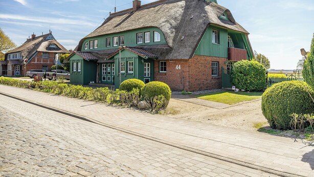 A traditional building with a steeply pitched roof, a brick facade, and a number '44' on the side. - Modern living under thatch - your stylish Bodden break for two (Born a. Darß)