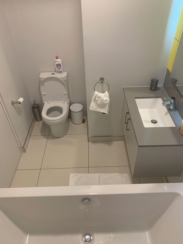 Un baño con inodoro, lavamanos y bañera.