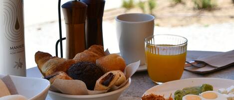Una mesa de desayuno con diversos alimentos, una cafetera y una botella.
