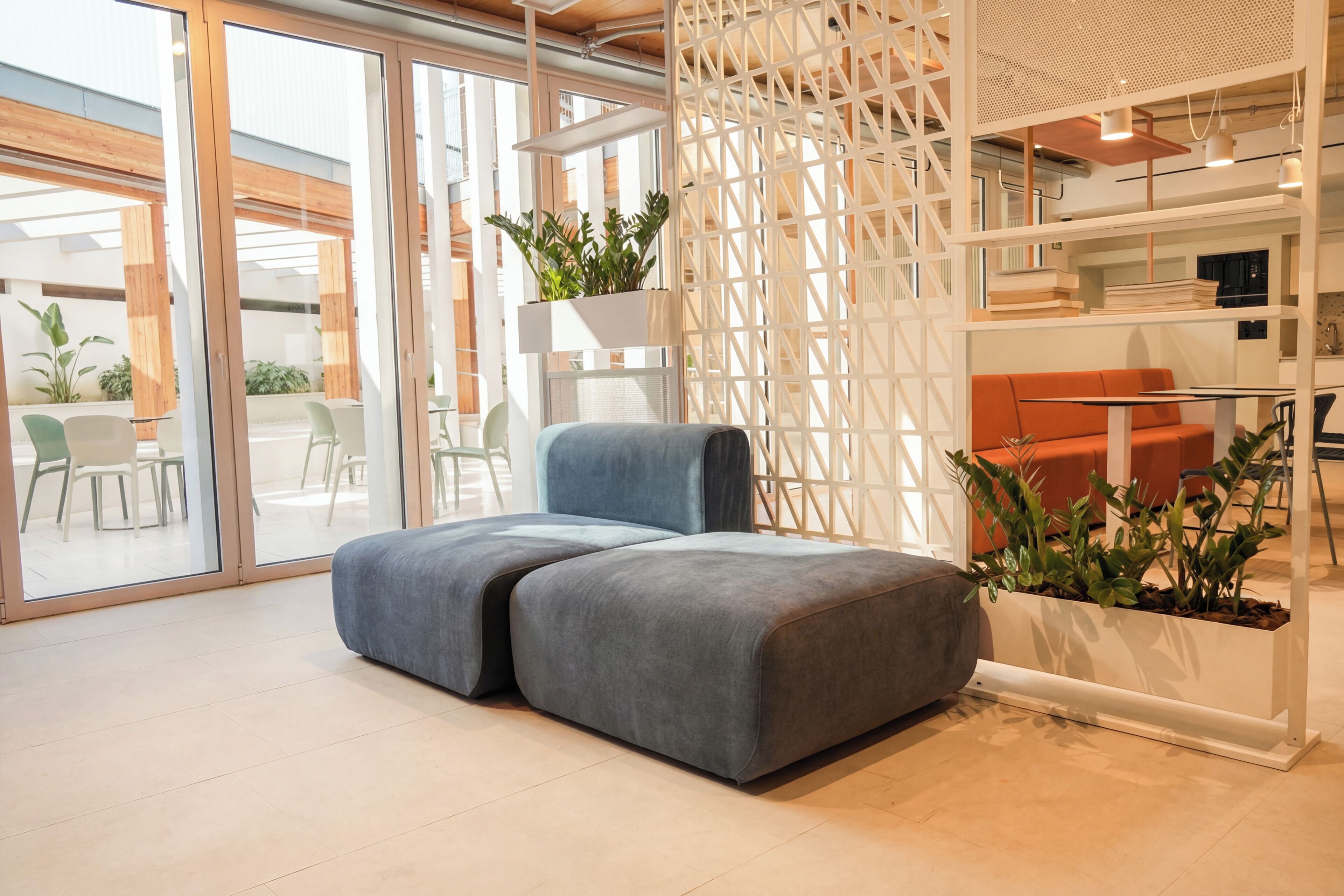 Un intérieur moderne comprenant un canapé d’angle, un coin repas et une cuisine.