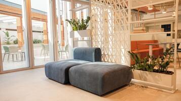 Een modern interieur met een modulaire bank, een eethoek en een keuken.