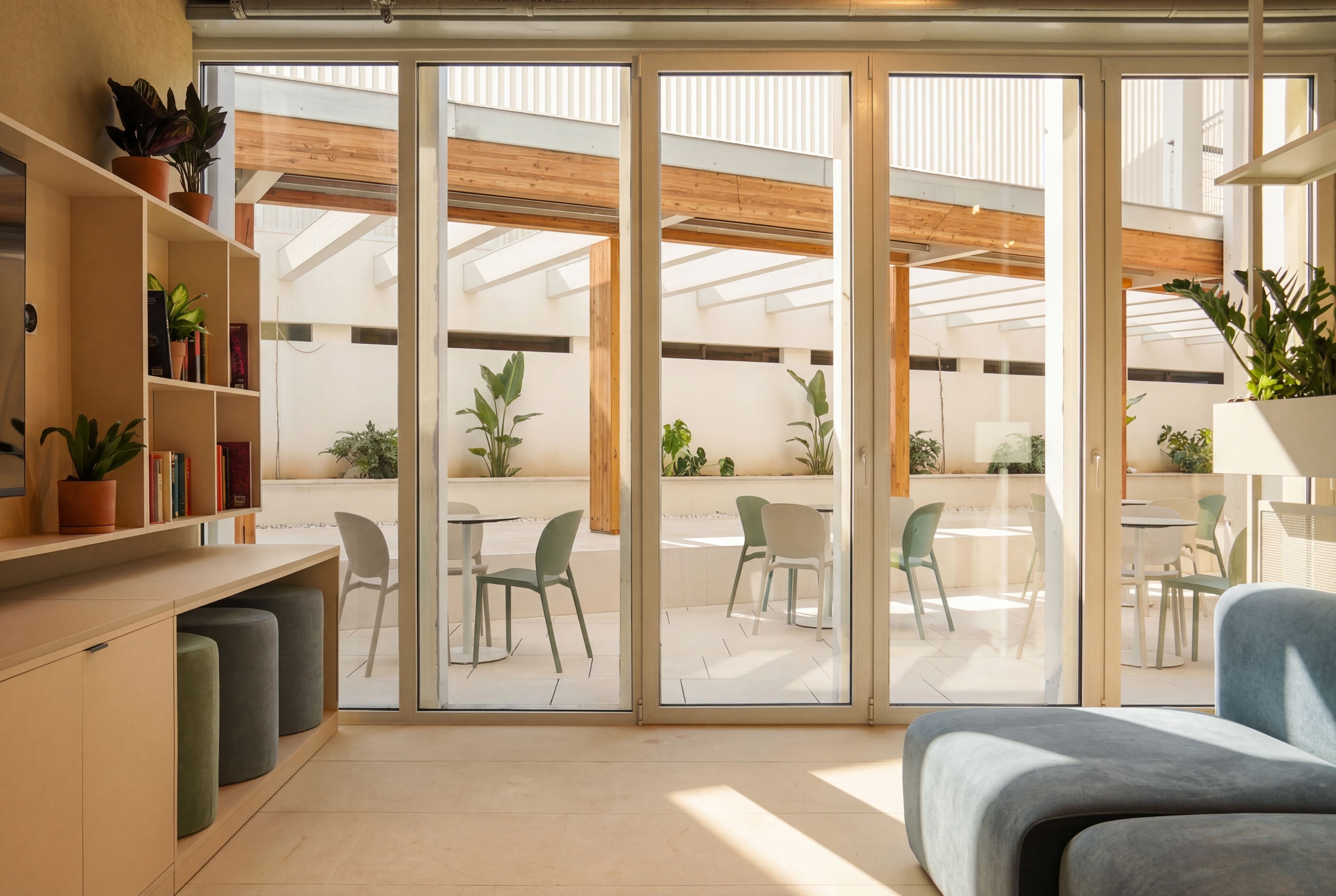 Et moderne interiør med en skydedør, der fører ud til en udendørs terrasse.