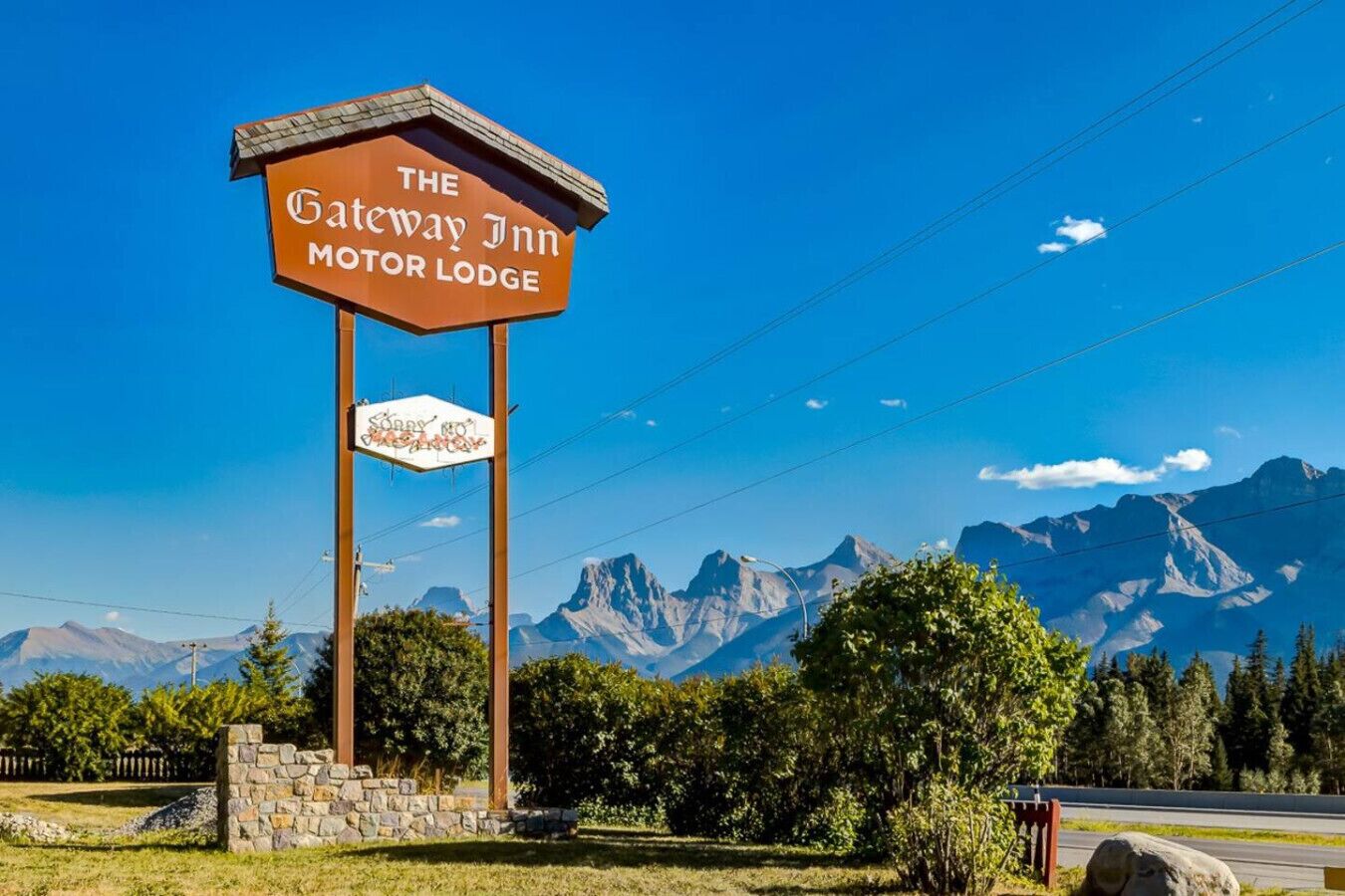 Señal del Motor Lodge The Gateway Inn, con montañas al fondo.
