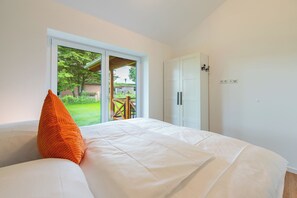 A bedroom with a bed, a window, and a wardrobe. - "Huus Klee" Vacation Home in Kating for up to 4 people (Kating)