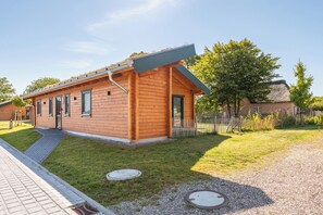 A single-story wooden building with a sloped roof, a small porch, and a gravel driveway. - "Huus Klee" Vacation Home in Kating for up to 4 people (Kating)