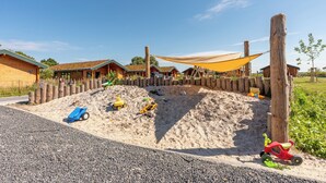 A children's play area with sand, toys, and a wooden fence. - Vacation home "Huus Klee" in Kating for up to 4 people (Kating)