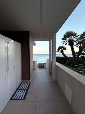 A corridor leading to a balcony with a view of the sea and palm trees. - Taormina 10, PANTA REI Fontane Bianche, VILLA on the beach (Fontane Bianche)