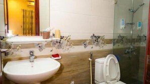 Une salle de bain avec un lavabo, des toilettes et une douche.