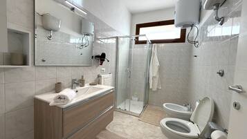 Chuveiro, secador de cabelo, toalhas de banho